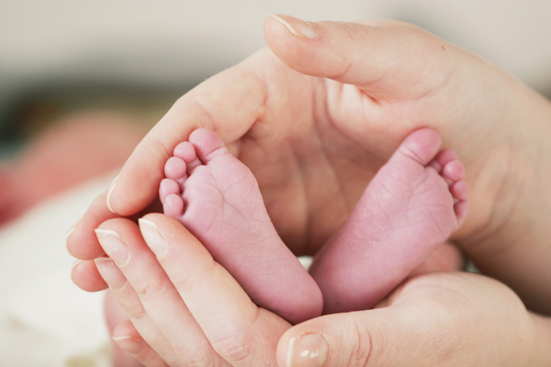 Babyfüße in einer Frauenhand